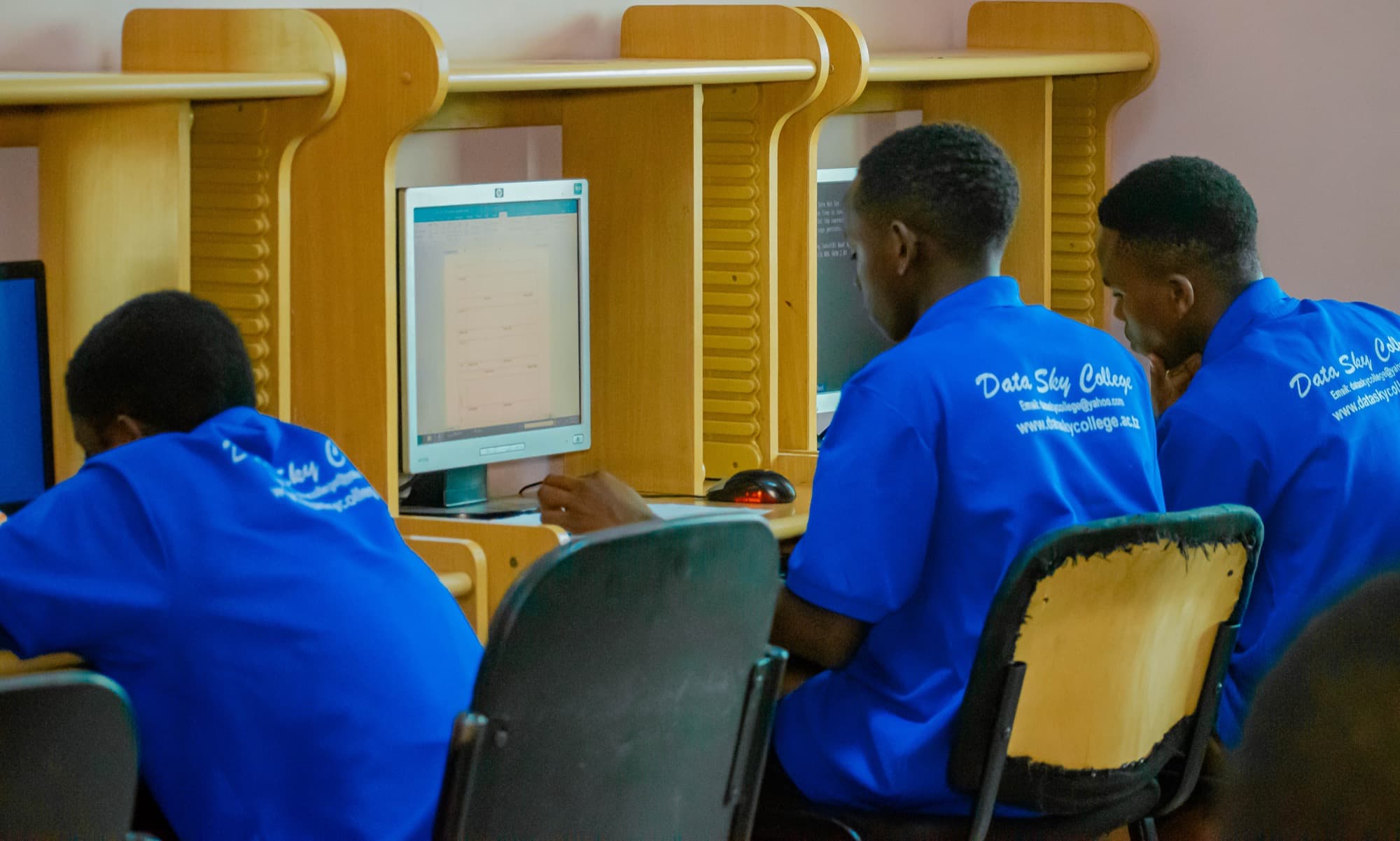 A wide view of Datasky College students working in a computer lab