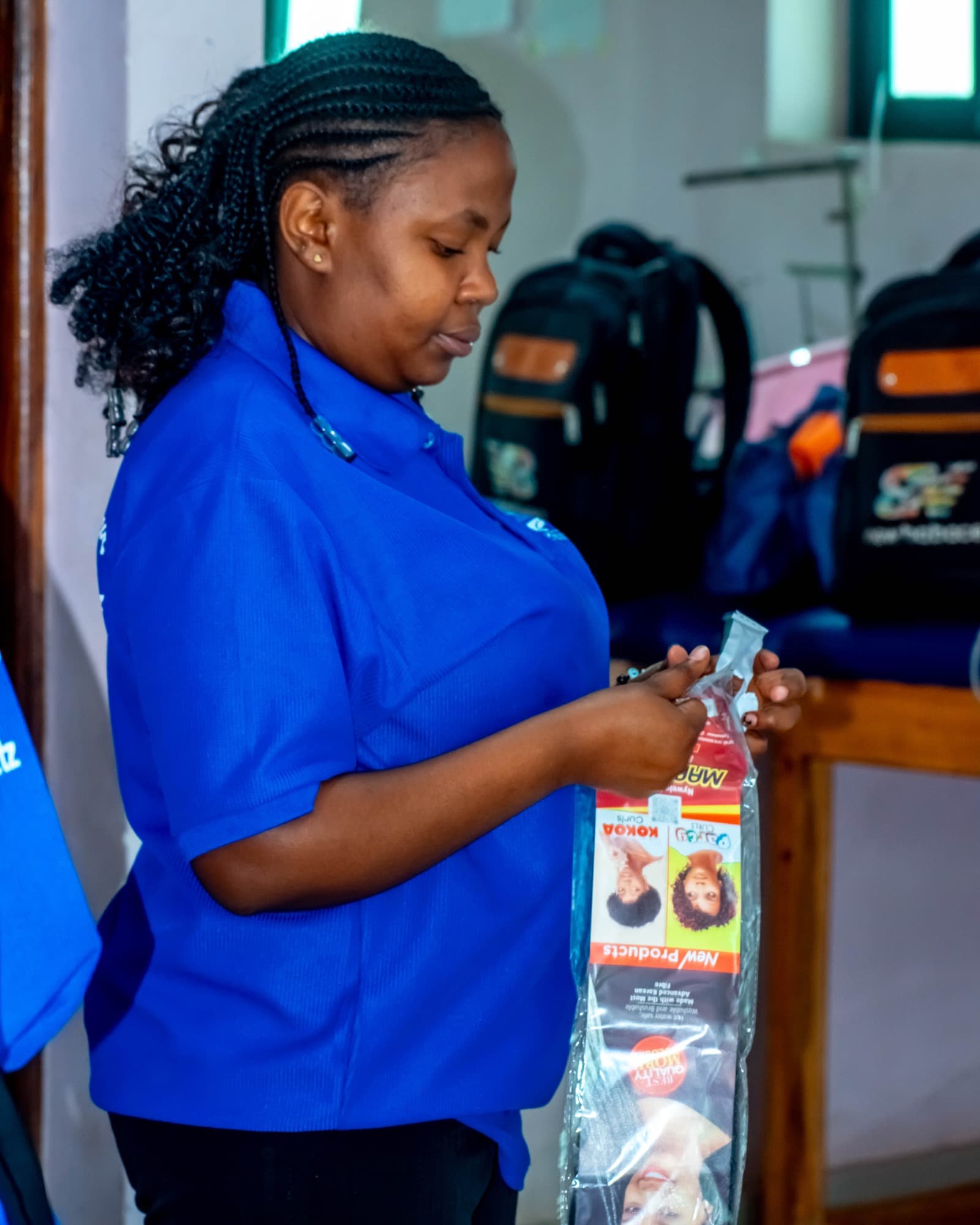 A Datasky College staff member in college uniform handling stock and product in the college store